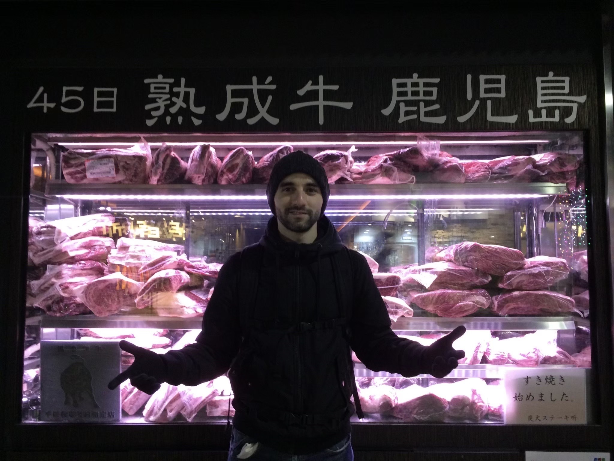 Standing in front of a meat-shop in Kagoshima, Japan